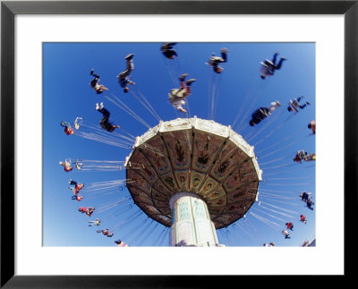 Blurry Colorful Amusement Park Ride With People Against A Bright White Sky by Guy Crittenden Pricing Limited Edition Print image