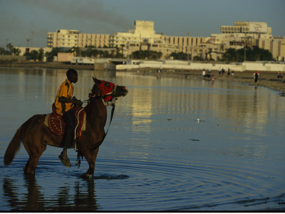 A Boy On Horseback Rides Along Jeddahs Waterfront by Reza Pricing Limited Edition Print image