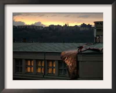 A Worker Cuts A Piece Off A Roof That Was Torn Away During A Storm In Prague, January 19, 2007 by Petr David Josek Pricing Limited Edition Print image