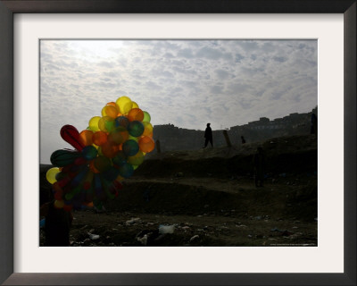 A Boy Walks As Selling Balloons In A Neighborhood In Kabul, Afghanistan, Thursday, August 24, 2006 by Rodrigo Abd Pricing Limited Edition Print image