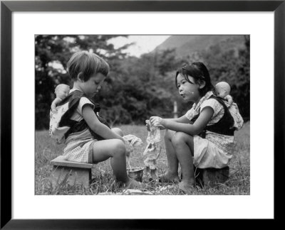 American Child Playing With Chinese Friend, Washing Doll Clothes by John Dominis Pricing Limited Edition Print image
