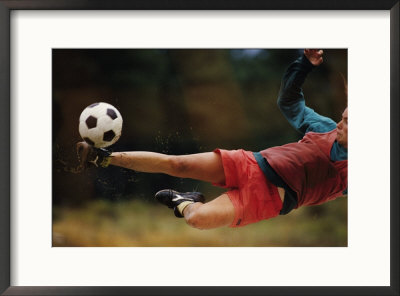 A Man Bends Sideways As He Kicks A Soccerball by Dugald Bremner Pricing Limited Edition Print image