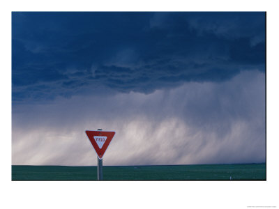 Rain Pours Out Of Dark Clouds On Plains Behind A Yield Traffic Sign by Peter Carsten Pricing Limited Edition Print image