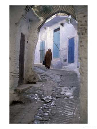 Traditionally Dressed Woman Along Cobblestone Alley, Morocco by John & Lisa Merrill Pricing Limited Edition Print image
