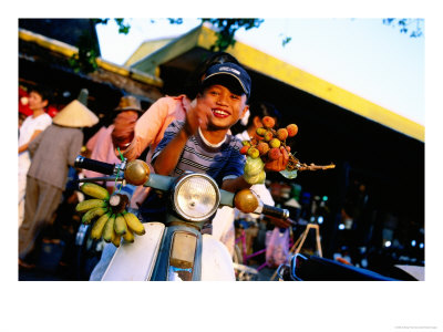 Smiling Boy On Motor Scooter At Market, Hoi An, Vietnam by Anthony Plummer Pricing Limited Edition Print image