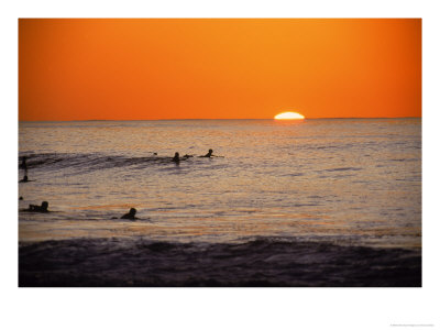 Surfers In Water At Sunset, Hawaii by Vince Cavataio Pricing Limited Edition Print image