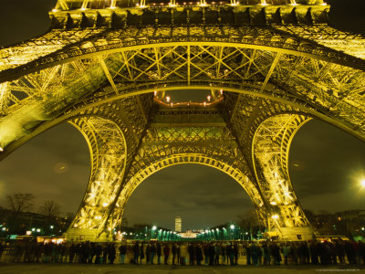 Line Of Tourists Queuing Under Eiffel Tower At Night, Paris, France by Kevin Levesque Pricing Limited Edition Print image