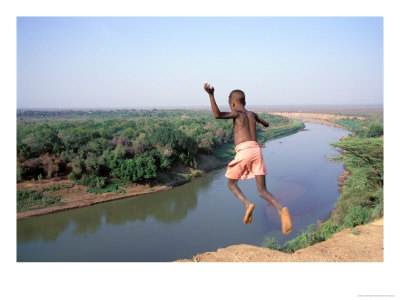 Karo Boy Leaps Off A Cliff Over The Omo River, Ethiopia by Janis Miglavs Pricing Limited Edition Print image