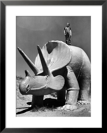 Young Boy Standing Atop Large Statue Of Dinosaur In Dinosaur Park Tourist Attraction by Alfred Eisenstaedt Pricing Limited Edition Print image