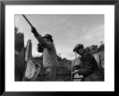 Herbert Lee Pratt Firing His Gun Toward A Grouse While The Loader Reloads Ammunition by John Phillips Pricing Limited Edition Print image