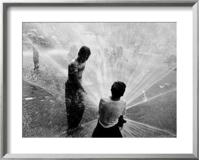 Children Playing In The Spray Of An Open Fire Hydrant To Escape The Ongoing Heat Wave by Peter Stackpole Pricing Limited Edition Print image
