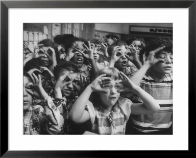 Classroom Full Of Students Circling Fingers Around Eyes In Form Of Glasses During Music Class by Francis Miller Pricing Limited Edition Print image