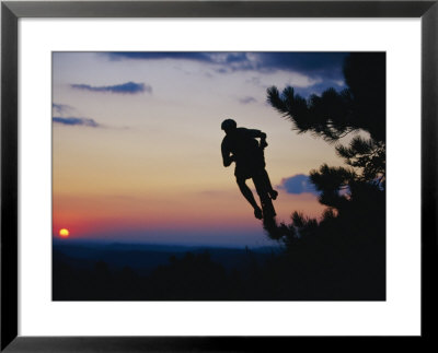 Silhouette Of Mountain Biker In The Air Against Sunset Sky by Skip Brown Pricing Limited Edition Print image