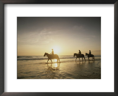 Horseback Riders Silhouetted On A Beach At Twilight, Costa Rica by Michael Melford Pricing Limited Edition Print image
