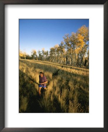 A Man Runs Through A Meadow Of Tall Grass Near Mt. Elden by John Burcham Pricing Limited Edition Print image