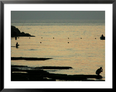Men Are Silhouetted Against The Sea As They Fish And Relax On The Beirut Coastline, August 24, 2006 by Matt Dunham Pricing Limited Edition Print image