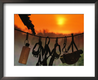 Caving Equipment And Bottle Hang On Line Against A Fiery Sun And Sky by Mark Cosslett Pricing Limited Edition Print image