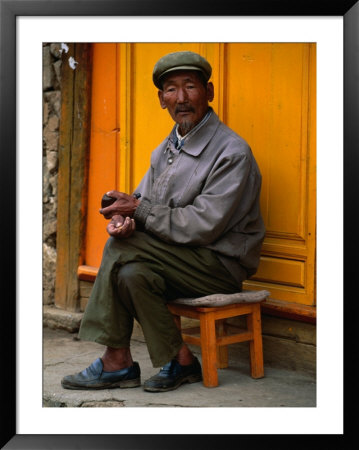 Man Sitting On Stool On Sidewalk, Looking At Camera, Baisha, China by Kraig Lieb Pricing Limited Edition Print image