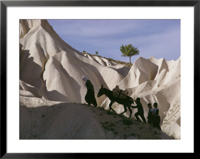 A Turkish Family And Their Donkey Climbing Cappadocia Rock Formations by Jonathan Blair Pricing Limited Edition Print image