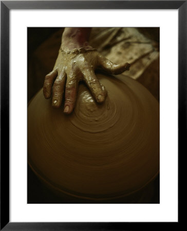 Close-Up Of The Brown Muddy Hand Of A Potter As He Spins A Clay Pot On His Wheel by Thomas J. Abercrombie Pricing Limited Edition Print image