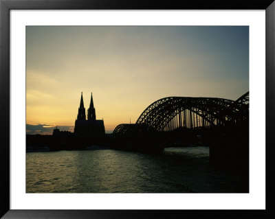 The Cologne Cathedral And Hohenzollern Bridge Silhouetted At Dusk by Raul Touzon Pricing Limited Edition Print image