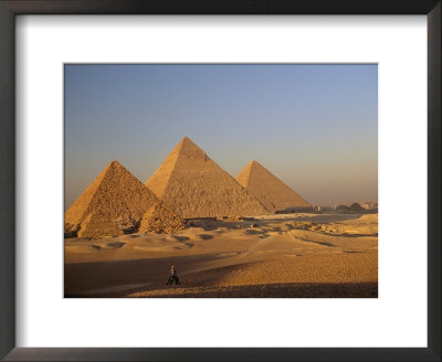 A Man On A Donkey In The Desert Near The Great Pyramids Of Giza by Kenneth Garrett Pricing Limited Edition Print image