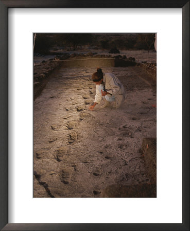 An Anthropoligist Examines 3.6 Million-Year-Old Laetoli Prints by Kenneth Garrett Pricing Limited Edition Print image