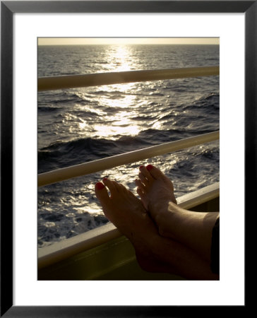 Woman's Feet Resting On The Railing Of A Cruise Ship At Sunset by Todd Gipstein Pricing Limited Edition Print image