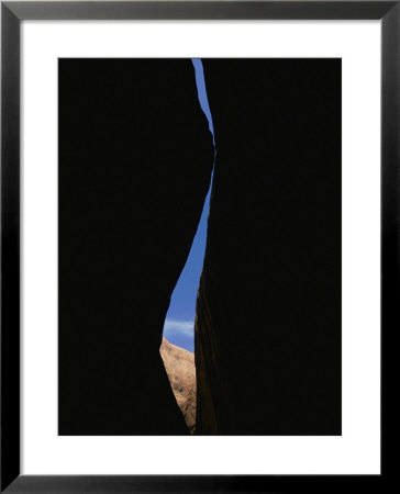 A Sliver Of Sky Streaks Through A Sinuous Opening Carved Into The Walls Of A Slot Canyon by Bill Hatcher Pricing Limited Edition Print image