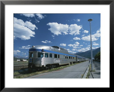Via Rail Canada Train Waiting At Jasper Station With Rockies In Background by Todd Gipstein Pricing Limited Edition Print image