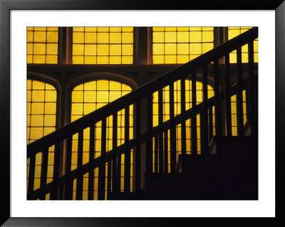 A Staircase In Silhouette Against A Yellow Stained Glass Window by David Evans Pricing Limited Edition Print image