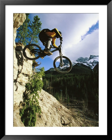 Man Jumping On His Mountain Bike With Ha Ling Peak In The Background by Mark Cosslett Pricing Limited Edition Print image
