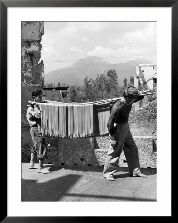 Boys Working In Pasta Factory Carry Rods Of Pasta To Drying Rooms by Alfred Eisenstaedt Pricing Limited Edition Print image