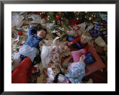 Children Laugh As They Lay In Wrapping Paper From Christmas Presents by Joel Sartore Pricing Limited Edition Print image
