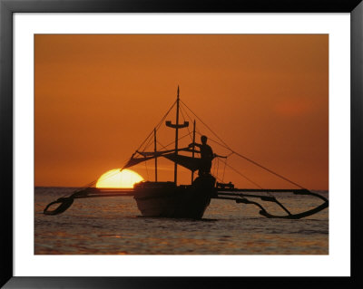 A Man And An Outrigger Silhouetted Against A Brilliant Orange Sky by Paul Chesley Pricing Limited Edition Print image