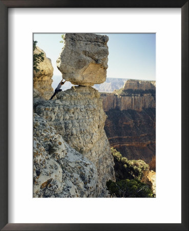 A Man Pretends To Push A Huge Boulder Into The Canyon by W. E. Garrett Pricing Limited Edition Print image