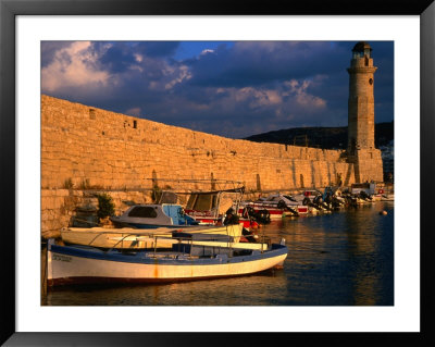 Fishing Boats Docked By Lighthouse Rethymno, Crete, Greece by Glenn Beanland Pricing Limited Edition Print image