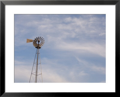 A Windmill Stands Tall Against A Cloudy Sky At Steven's Creek Farm by Joel Sartore Pricing Limited Edition Print image