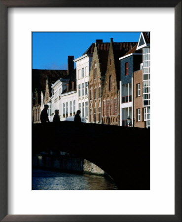 Pedestrians Crossing Canal And Houses Near Jan Van Eyckplein, Bruges, Belgium by Martin Moos Pricing Limited Edition Print image