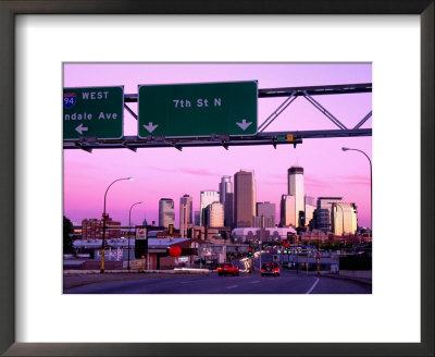 Traffic Signs Over Highway With City Skyline Beyond At Dusk, Minneapolis, United States Of America by Richard Cummins Pricing Limited Edition Print image