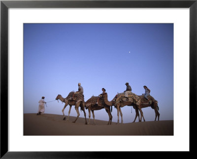 Sunset Camel Ride, Al Maha Desert Resort, Dubai, United Arab Emirates by Holger Leue Pricing Limited Edition Print image
