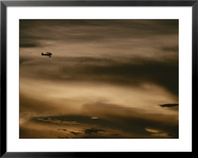A Small Airplane Flies Through A Cloudy Sky Over Key West, Florida by Raul Touzon Pricing Limited Edition Print image