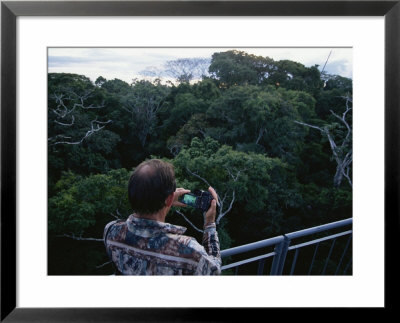 A Man With A Camera Enjoys The Forest Canopy From An Observation Deck by Maria Stenzel Pricing Limited Edition Print image