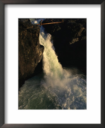 Man Crosses A Log Bridge Above A Waterfall On The Yagtali River by Randy Olson Pricing Limited Edition Print image