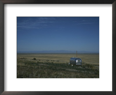 A Camper Sits On A Hill Looking Out Across A Plain by Taylor S. Kennedy Pricing Limited Edition Print image