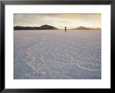 A Distant Figure Stands With Arms Upraised On The Immense Salt Flat by Walter Meayers Edwards Pricing Limited Edition Print image