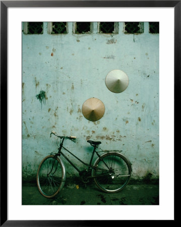 Conical Hats Hang On Wall Above Bicycle In Historic Old Quarter, Hanoi, Vietnam by Richard I'anson Pricing Limited Edition Print image