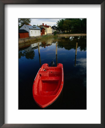 Red Boat Moored In Water With Houses In Background, Ekenas, Finland by Wayne Walton Pricing Limited Edition Print image
