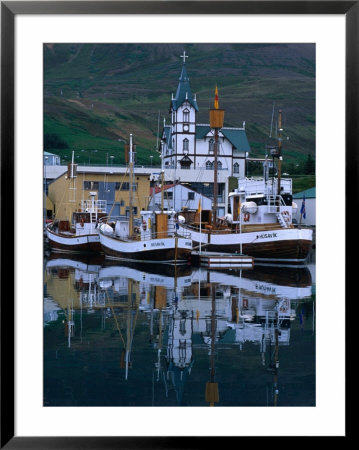 Traditional Oak Fishing Boats In Front Of Husavikurkirkja Church, Husavik, Iceland by Grant Dixon Pricing Limited Edition Print image