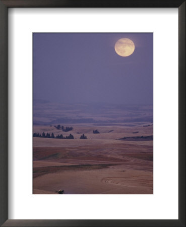 A Combine Chews Through An Undulating Field Of Wheat Under A Huge Full Moon by Robert Madden Pricing Limited Edition Print image